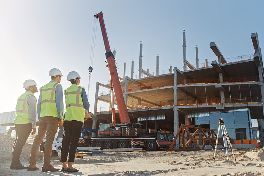 Surety Bonds - View of Three Contractors Standing on a Construction Jobsite Watching the Building Progress